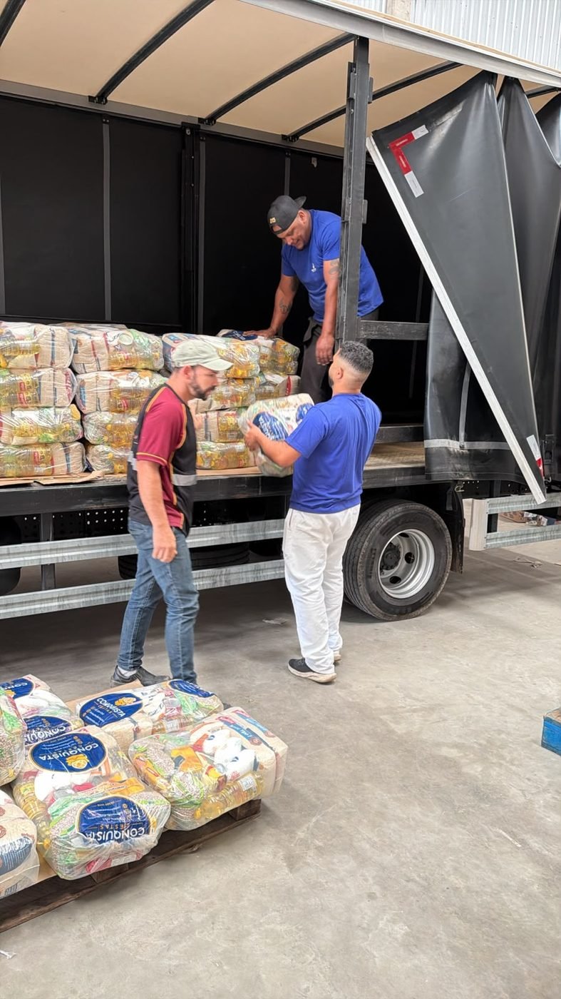 Equipe Conquista carregando cestas básicas no caminhão